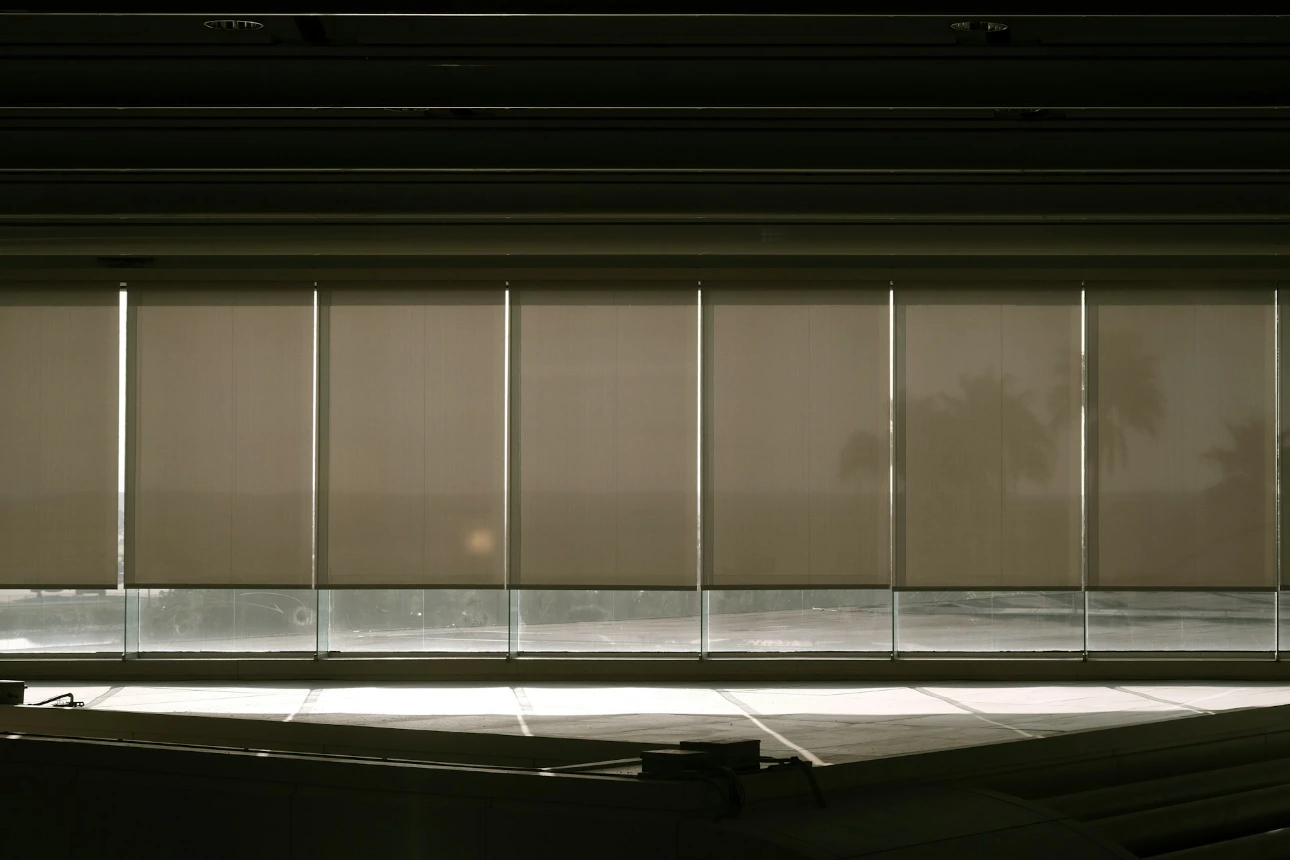 a window with blinds in a dark room